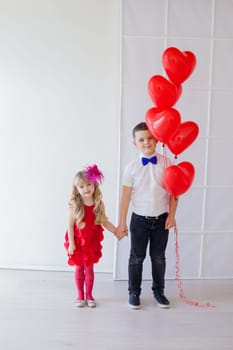 children with red heart balloons
