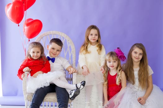 Boy and girls sit together with balloons