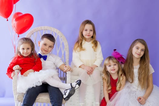 Boy and girls sit together with balloons