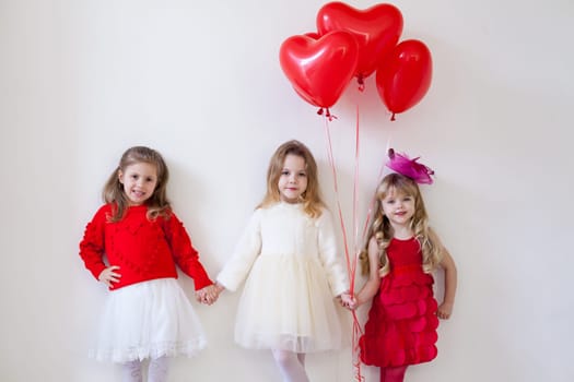 Three little beautiful girls hold hands