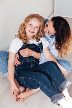 Mom and daughter play cuddles at home