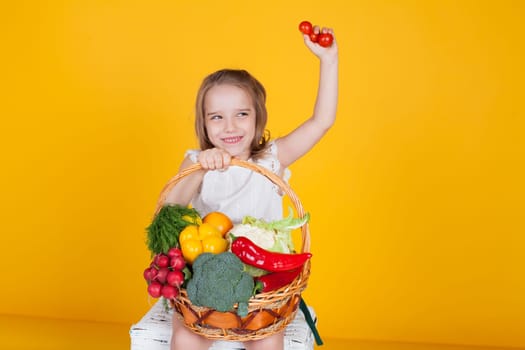 girl holds a basket with ripe vegetables