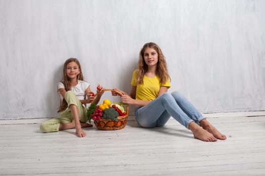 Girls hold ripe vegetables and fruits