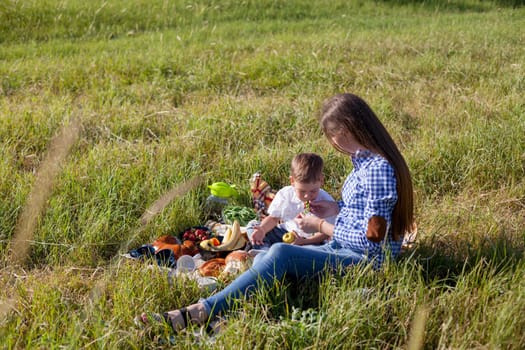 Mom and son eat in park picnic in nature