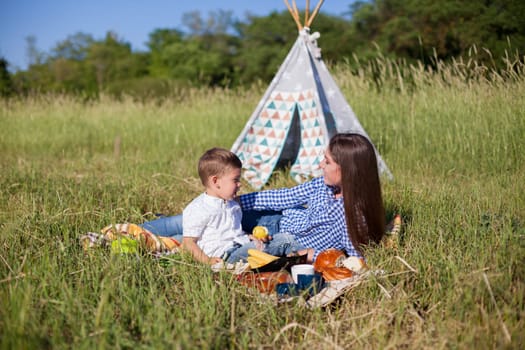 Mom and son eat in park picnic in nature