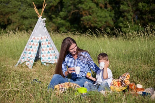 Mom and son eat in park picnic in nature