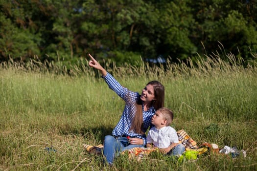 Mom and son eat in park picnic in nature