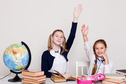 two schoolgirl at the desk in a geography class