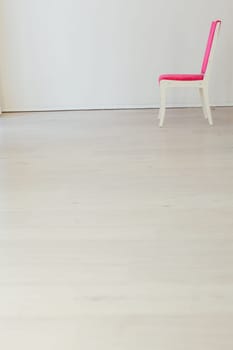 pink chair stands alone in the room