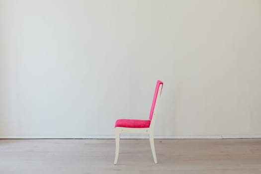 pink chair stands alone in the room