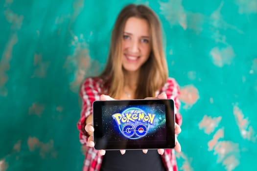 Ufa, Russia. - July 29: Woman show the tablet with Pokemon Go logo