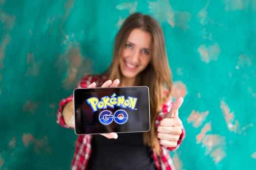 Ufa, Russia. - July 29: Woman show the tablet with Pokemon Go logo