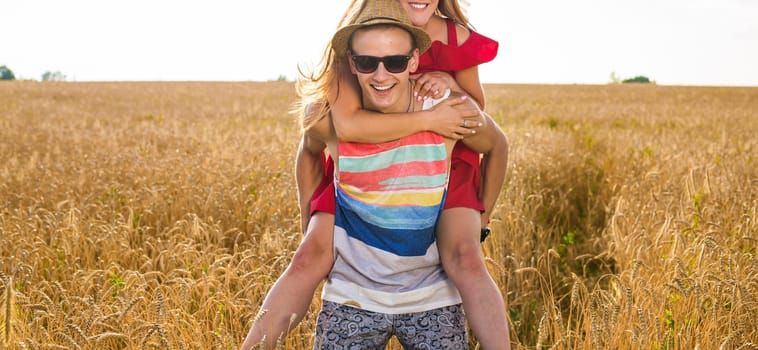 Couple Having Piggyback In Summer Harvested Field.