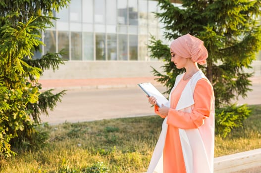 Young Muslim woman standing , holding document paper