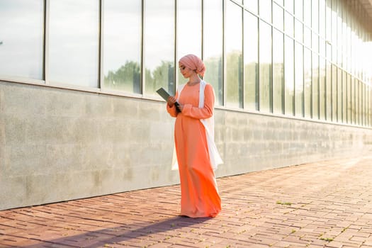 Young Muslim woman standing , holding document paper