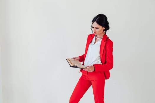 female student in red business suit with book in hand