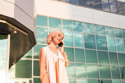 Portrait of Muslim woman wearing Hijab outdoor using mobile phone.