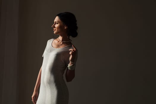 Portrait of a brunette woman in a striped dress