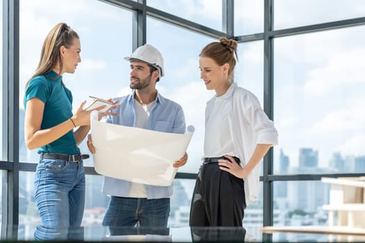Group of architect engineer looking at project plan while brainstorming idea about building structure. Manager team discuss about building construction while standing near with city view. Tracery.