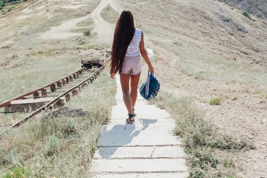 beautiful woman with long hair descends stairs in the mountains