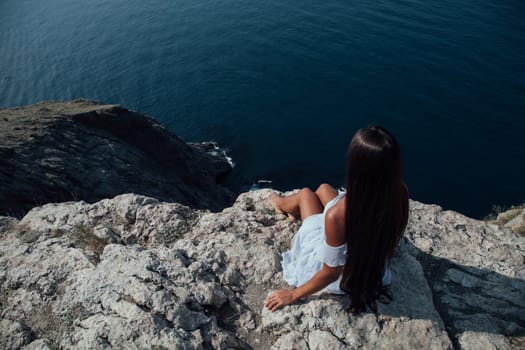 beautiful woman with long hair on a cliff cliff ocean