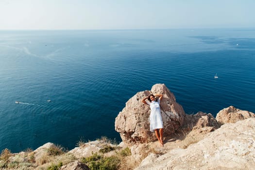 beautiful woman with long hair on a cliff cliff ocean