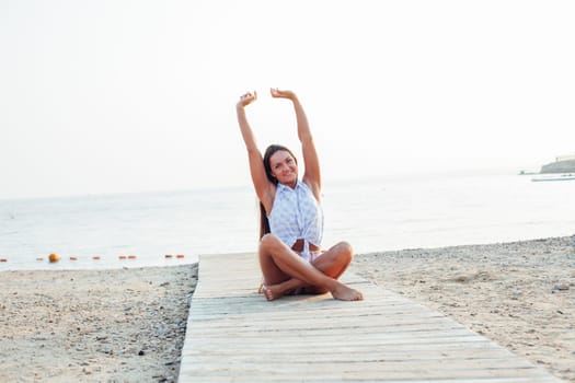 Beautiful woman with long hair walks on the beach yoga