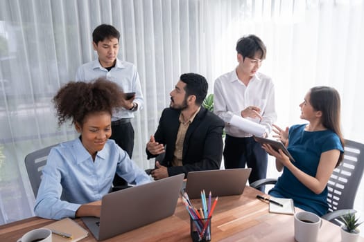 Happy diverse business people work together, discussing in corporate office. Professional and diversity teamwork discuss business plan on desk with laptop. Modern multicultural office worker. Concord