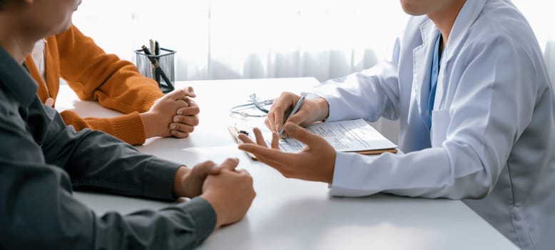 Couple attend fertility consultation with gynecologist at hospital as part family planning care for pregnancy. Loving husband and wife support each other through the doctor appointment. Panorama Rigid