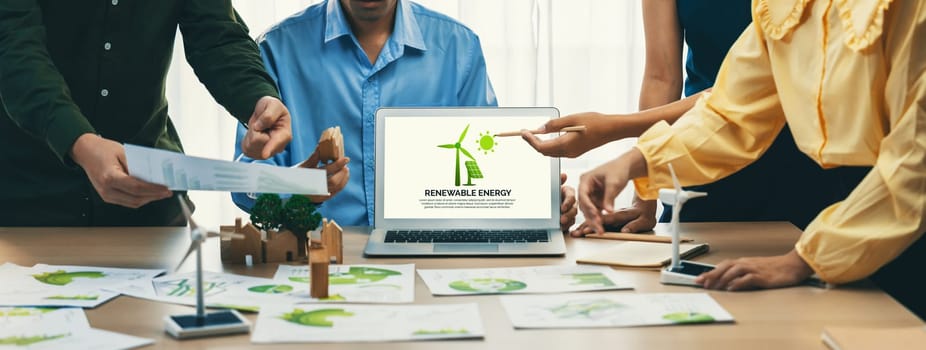 Renewable energy logo displayed on green business laptop while business team represented green design to customer. ESG environment social governance and Eco conservative concept. Closeup. Delineation.