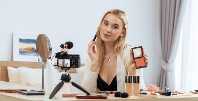 Young woman making beauty and cosmetic tutorial video content for social media. Beauty blogger smiles to camera while showing how to beauty care to audience or followers. Panorama Blithe