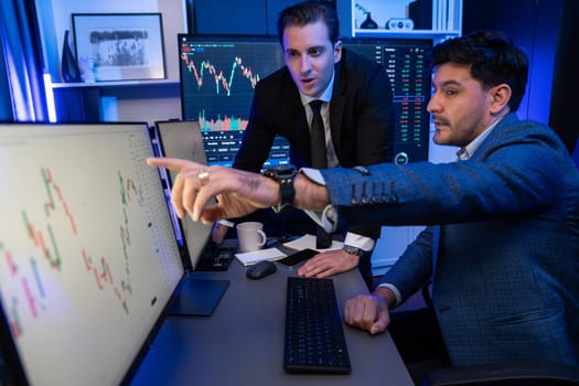 Stock exchange traders looking on high profit chart investment in panorama view, analyzing on monitor at night. Concept of discussing financial technology growth in neon light at workplace. Sellable.