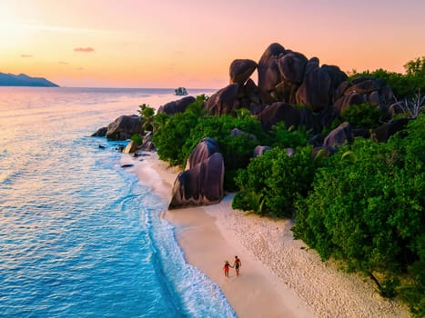 Anse Source d'Argent beach, La Digue Island, Seychelles, Drone aerial view of La Digue Seychelles,couple men and woman walking at the beach during sunset at a luxury vacation at sunset