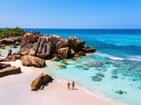 Anse Cocos beach, La Digue Island, Seychelles, Drone aerial view of La Digue Seychelles bird eye view of tropical Island, couple men and woman walking at the beach during sunset