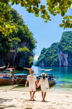 Men and women at the Tropical lagoon beach of Koh Loa Lading Krabi Thailand part of the Koh Hong Islands in Thailand. beautiful beach with limestone cliffs and longtail boats