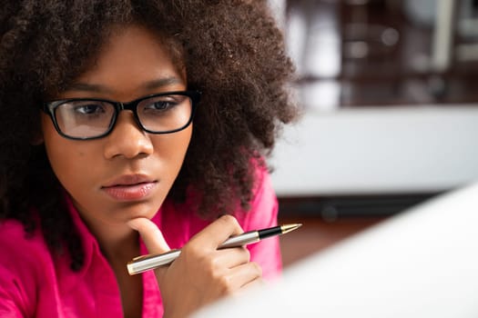 Portrait of young African woman creating website developer, thinking data information designer at home office, focusing on laptop. Concept of analytical data center in java project job. Tastemaker.