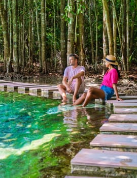 a couple of men and women visit the Emerald Pool and Blue Pond in Krabi Thailand, the tropical lagoon in a national park with trees, and mangroves with crystal clear water