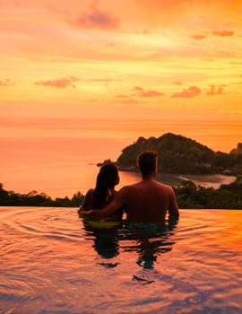 a young couple of men and women at a swimming pool during a vacation on a tropical island. man and woman in an infinity pool during sunset at a luxury vacation in Thailand