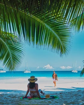 Anse Lazio Praslin Seychelles, a young couple of men and women on a tropical beach during a luxury vacation in Seychelles.