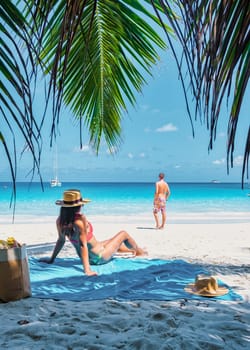 Praslin Seychelles tropical island with white beaches and palm trees, a couple of men and women on vacation at Seychelles visiting the tropical beach of Anse Lazio Praslin Seychelles.