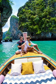 Luxury Longtail boat in Krabi Thailand, couple man, and woman on a boat trip to the tropical island, 4 Island trip in Krabi Thailand. Asian woman and European man mid age on vacation in Thailand.