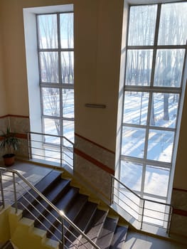 The stairs lead to the second and third floors of the hospital. Next to the stairs there are large windows facing the street. View from above