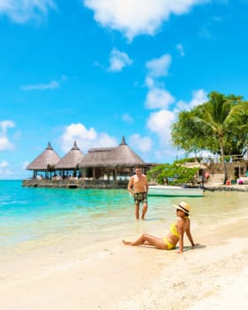 Man and Woman on a tropical beach in Mauritius, a couple on a honeymoon vacation in Mauritius on a sunny day with turqouse colored ocean