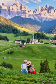 Couple viewing the landscape of Santa Maddalena Village in the Dolomites Italy, Santa Magdalena village Dolomites mountains, Val di Funes valley Trentino Alto Adige region, South Tyrol Italy