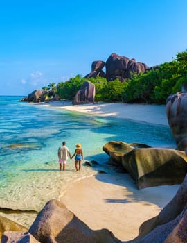 Anse Source d'Argent beach, La Digue Island, Seychelles, couple men and woman relaxing at the beach at a luxury vacation in the Seychelles La Digue Island