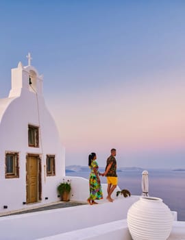 Men and women visit the whitewashed Greek village of Oia Santorini, a couple watching the sunrise in Santorini during vacation