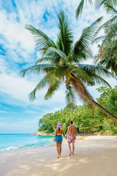 Couple walking at Surin Beach in Phuket southern Thailand, Surin Beach is a very famous tourist destination in Phuket, a tropical beach with palms around. Holiday and vacation concept