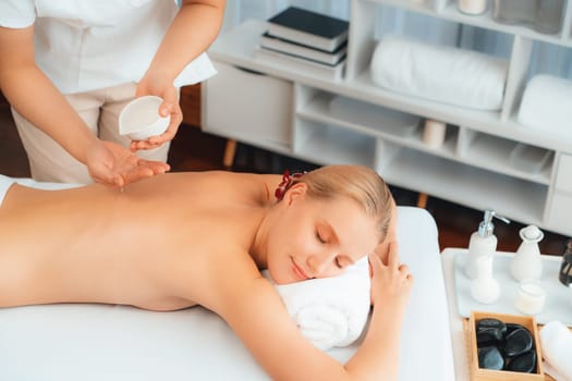 Masseur hands pouring aroma oil on woman back. Masseuse prepare oil massage procedure for customer at spa salon in luxury resort. Aroma oil body massage therapy concept. Quiescent