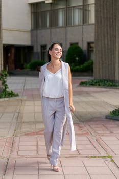 Happy businesswoman smiling while standing in suit on city street