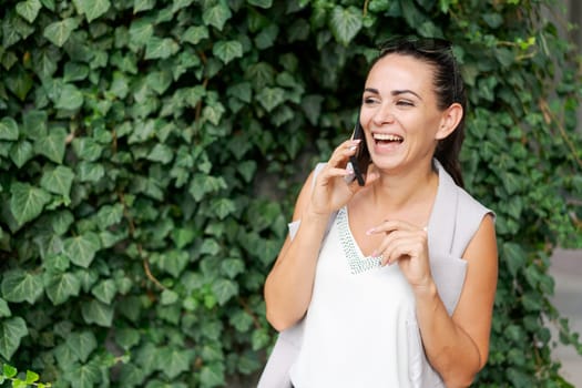 Business woman talking on mobile phone outdoors, professional woman in suit